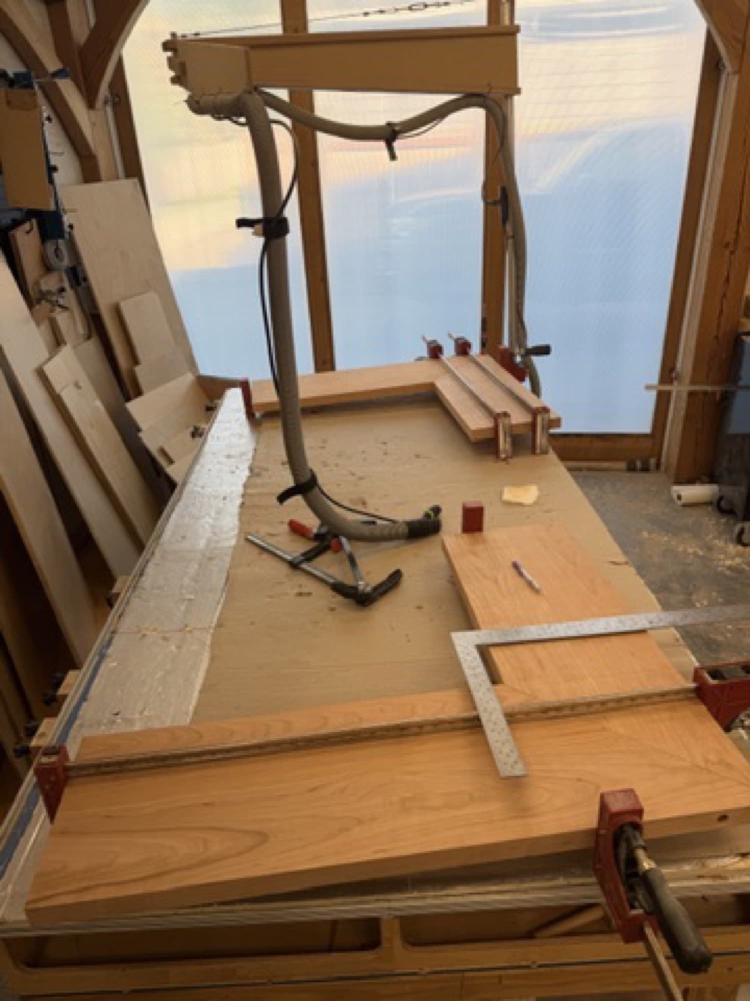 Close view of two mitered cherry shelf corners being checked on the bench
